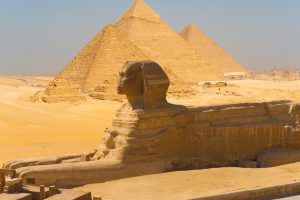 A side view of the great Sphinx with all of the pyramids of Giza in the background in Cairo, Egypt